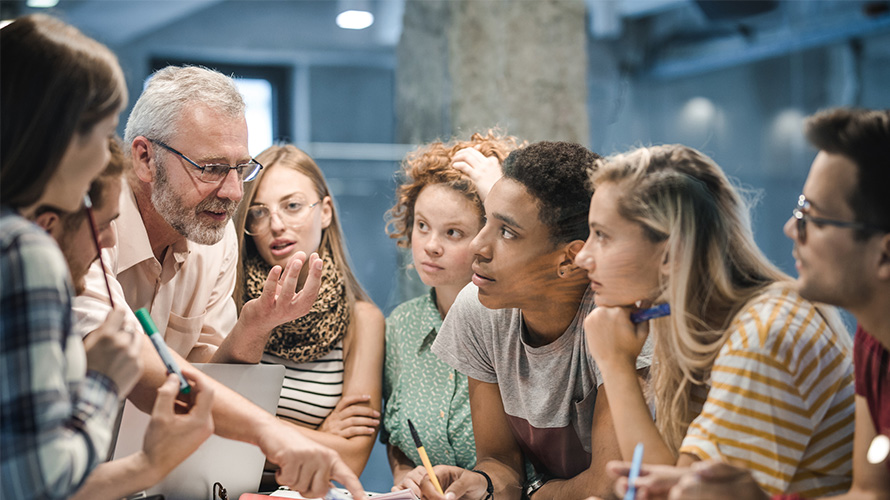 professor speaking with a group of students