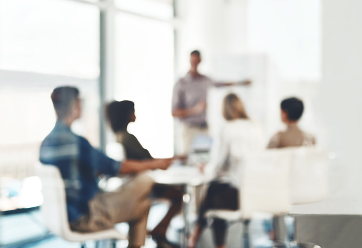 a blurred image of people attending a presentation